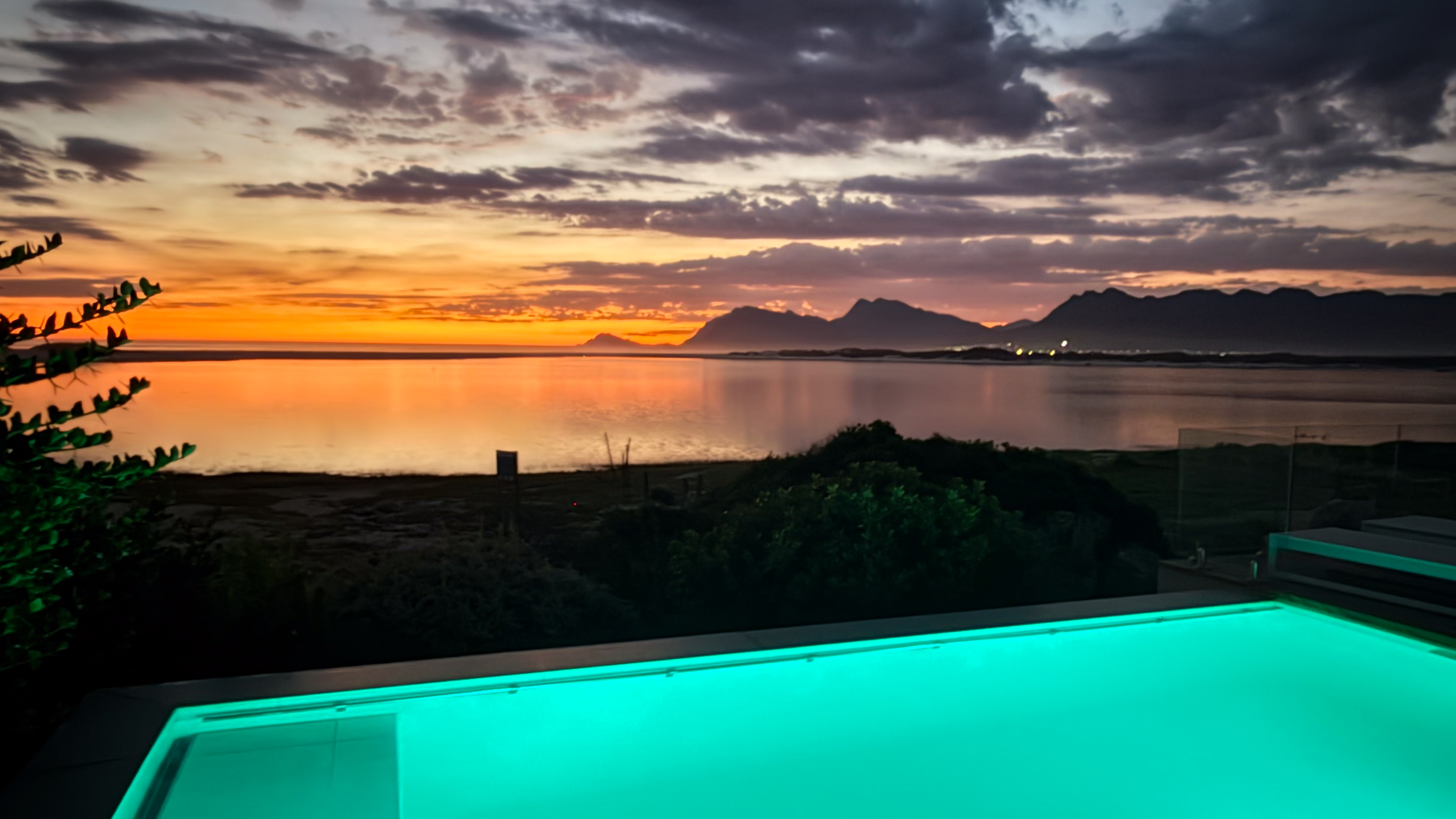 MBIZI lagoon house private pool illuminated at sunset with panoramic views of the Kleinrivier Lagoon and Overberg mountains