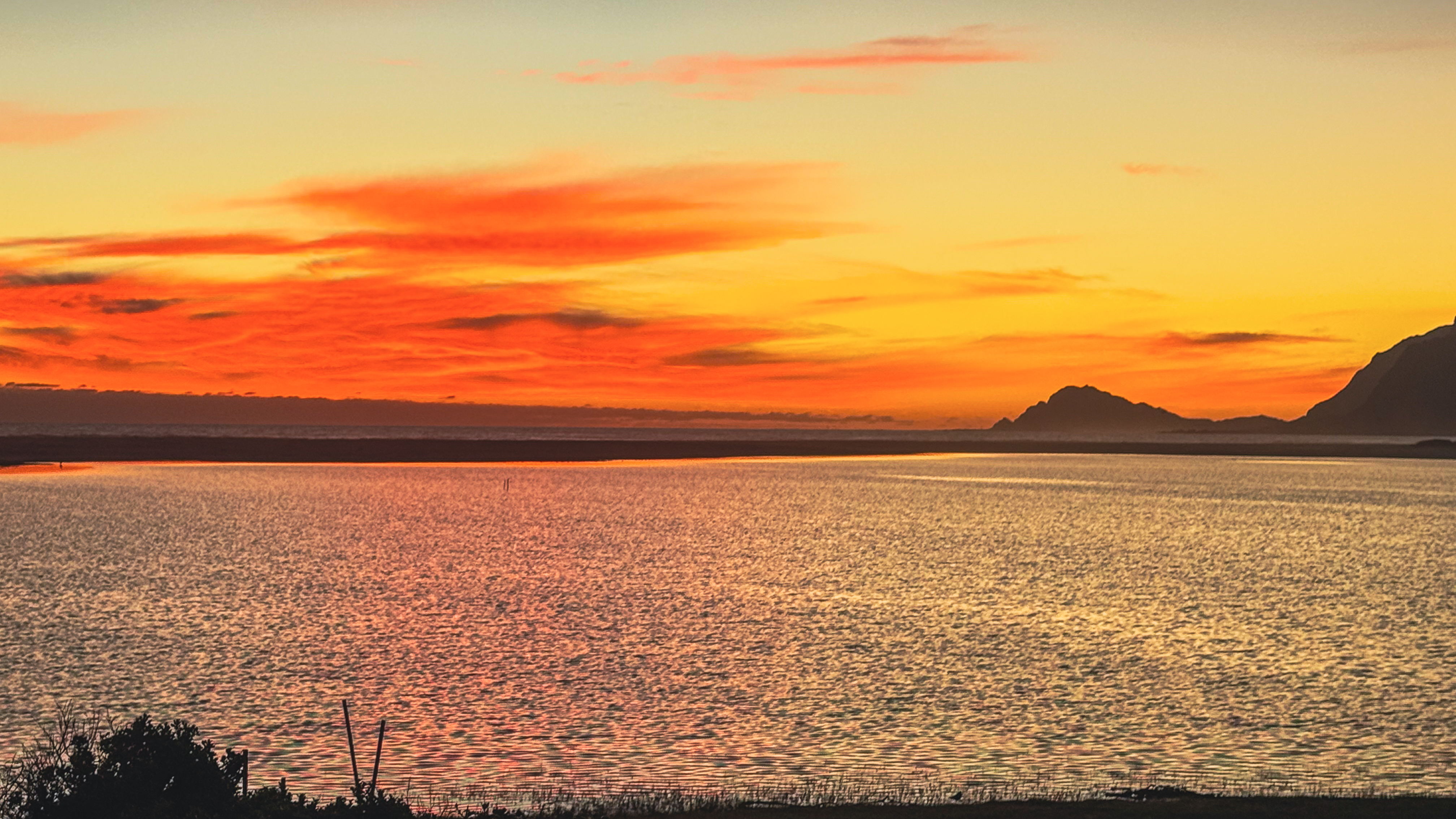 Dramatic orange and red sunset over the Kleinrivier Lagoon at Fisherhaven, with the mountains of the Overberg silhouetted against the sky