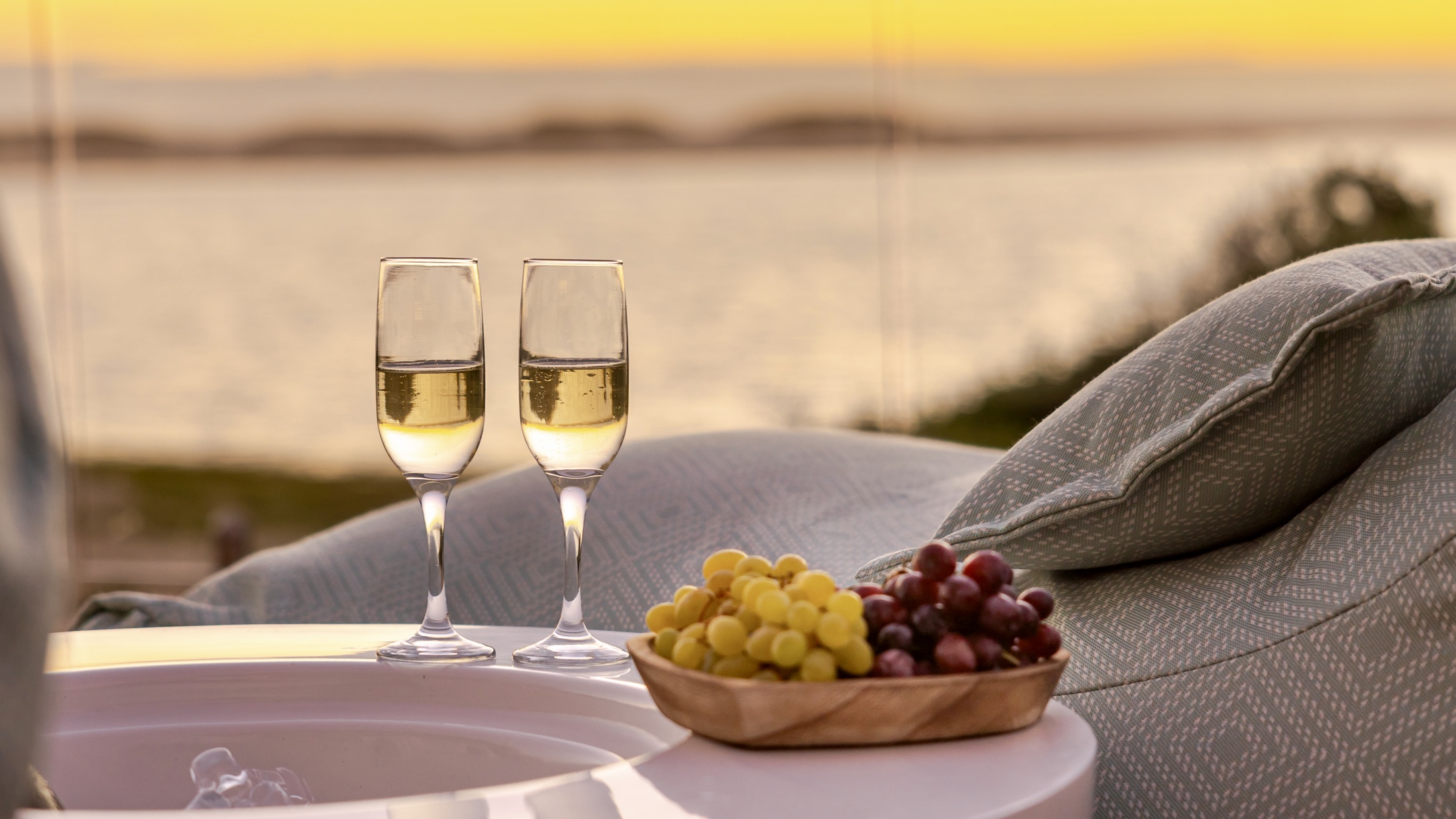 Sundowners on the MBIZI lagoon house terrace at sunset — the perfect end to a day of whale watching near Hermanus